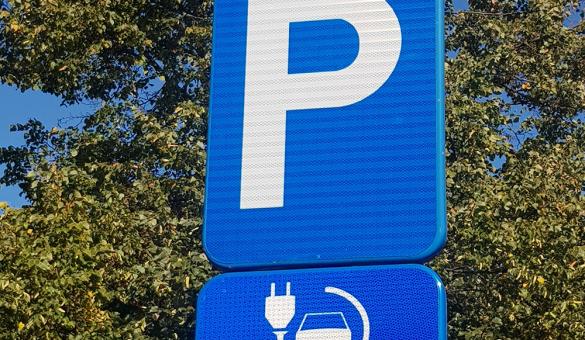 Blauw verkeersbord met witte hoofdletter P. Daaronder een kleiner blauw bord met een witte stekker en een auto.